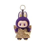 Purple plush keychain with a gold skirt on a white background
