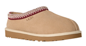Tan UGG slipper with a patterned tongue on a white background